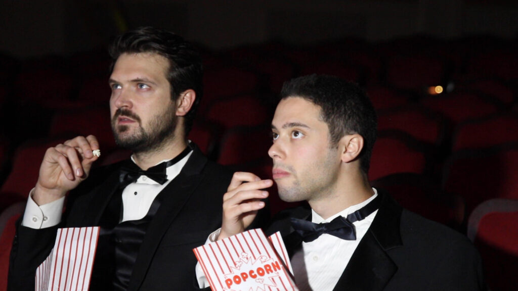 Christian Nilsson & Eric Tabach looking seriously towards screen in a theater